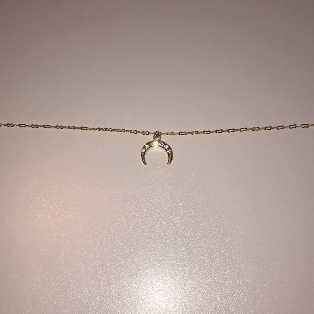 This is a gold necklace with a crescent moon